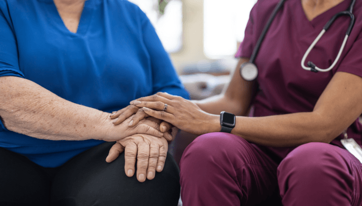 A doctor holding a patients hands