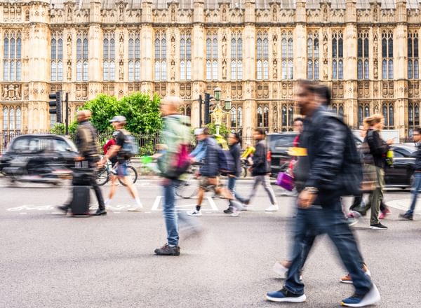 London, a busy street outside the houses of parliament, with blurred people walking in front of the grand building