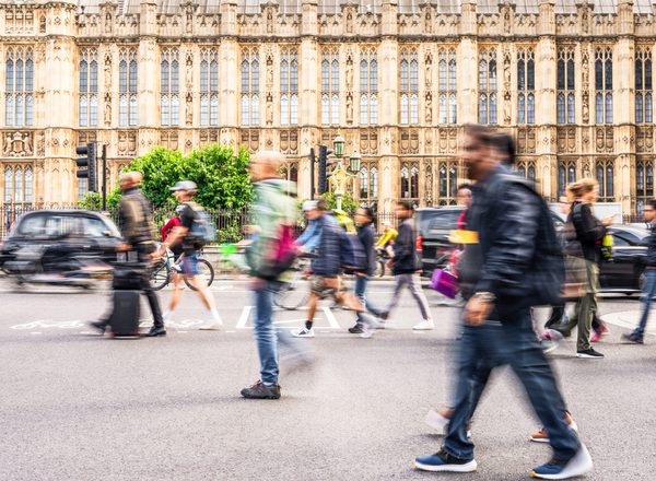 London, a busy street outside the houses of parliament, with blurred people walking in front of the grand building