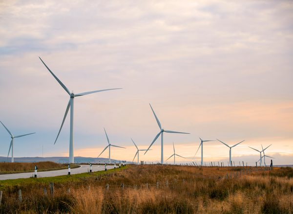A beautiful sunset in the Scottish highlands with renewable energy wind turbines far into the horizon