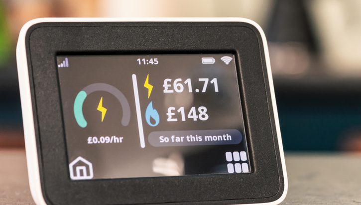 An energy smart meter sits on a countertop. It reads electricity: £61.71, gas: £148