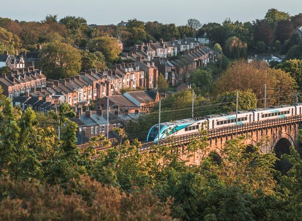 Townhouses beside the railway on the viaduct with a running train in Durham, UK
