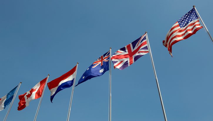 Many national flags against blue sky