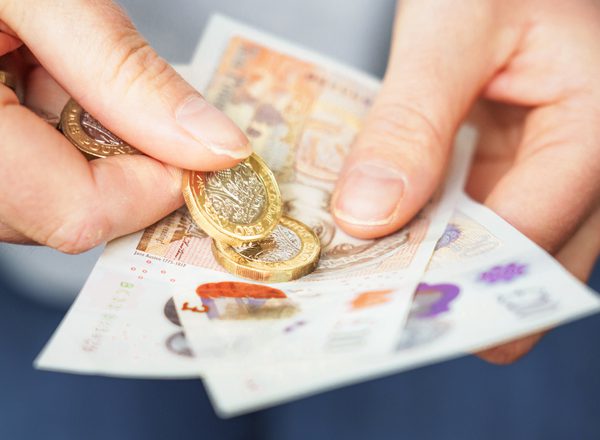 Close-up as a woman prepares cash for payment.