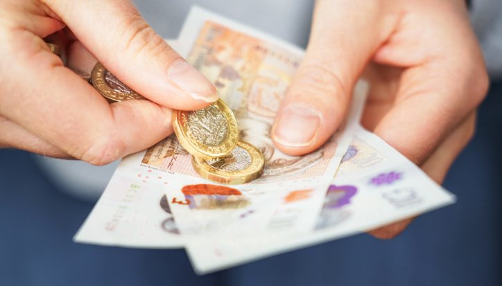 Close-up as a woman prepares cash for payment.