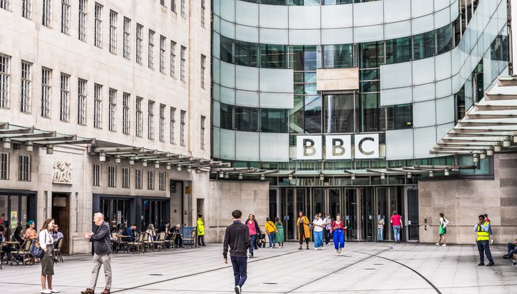 The outside of the BBC building in London with people walking in front of it
