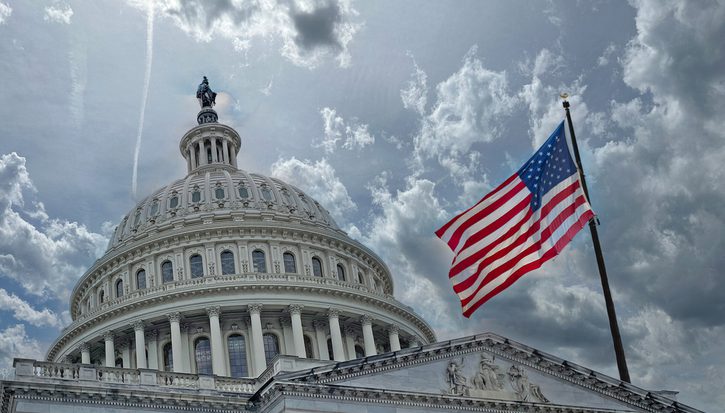 The White House in Washington DC, cloudy skies and US flag