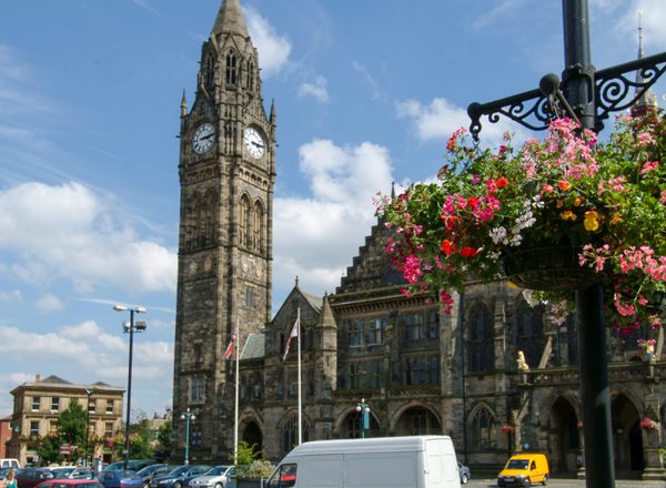 The outside of Rochdale town hall on a sunny day, with flowers in the foreground