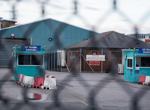 A UK border controls office behind a chain linked fence