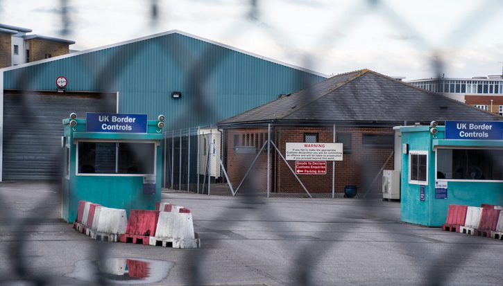 A UK border controls office behind a chain linked fence
