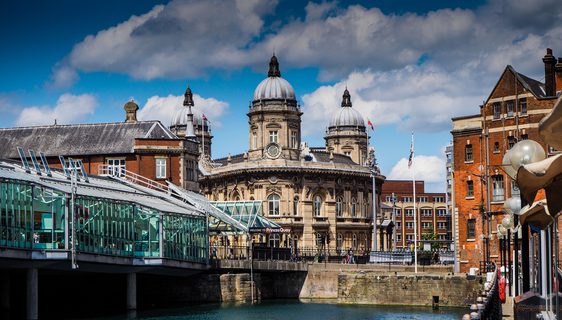 A view of Hull on a sunny day. Water in the foreground and buildings behind