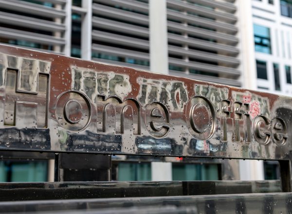 A closeup of an aged, graffiti-covered sign that reads Home Office