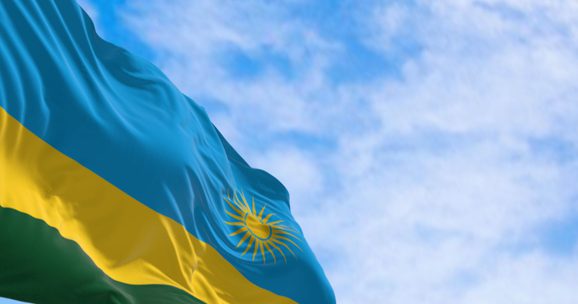 Rwandan flag against a blue sky